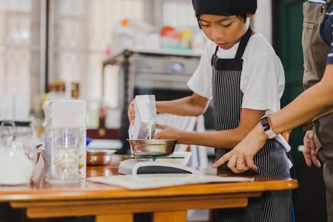 Young boy measuring ingredient for baking in kitchen. Stockillustratie