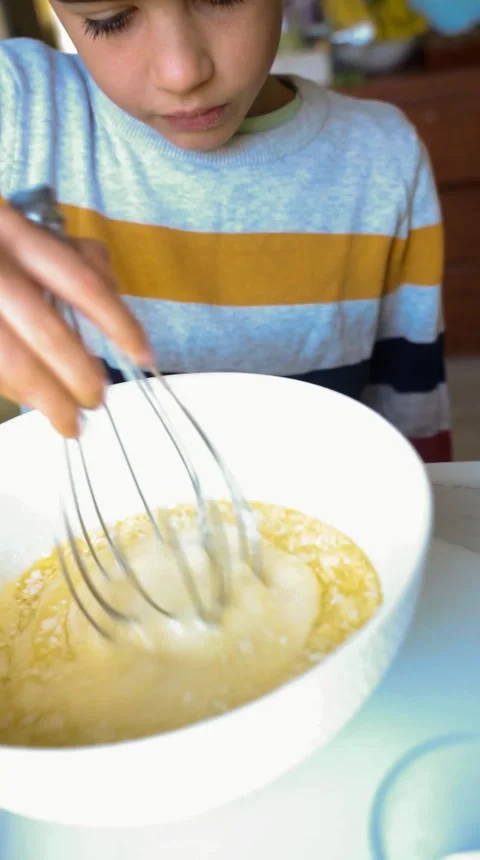 Young boy mixing the ingredients of a cake with a rod Stock Footage 250971595