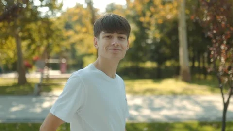 Young Boy with Mobile Phone, Looking at Camera, Embracing Tech Freedom Stock Footage 331250514