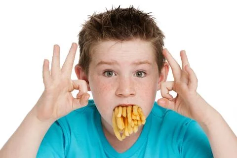 Young boy with mouth full of chips Stock Photos