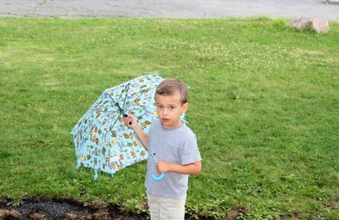 Young boy with an open umbrella Stock Photos