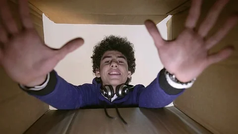 Young boy opens a parcel box with different emotions and being surprised. Video stock 80162461