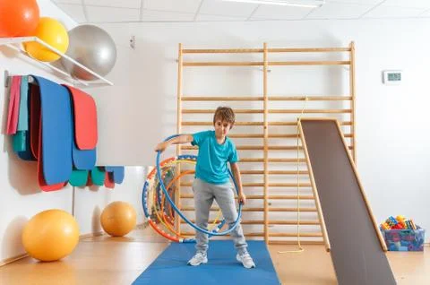 Young boy performs exercises with hula hoop in the gym. Foto stock