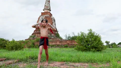 Young Boy Performs Traditional Muay Thai Boxing at Ancient Temple Stock Footage 337878109