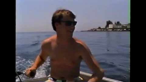 Young boy piloting boat. Eolie Islands, Sicily Italy 90s amateur movie Vídeos de archivo 123906631