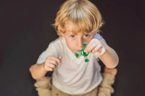 Young boy play with fidget spinner stress relieving toy Stock Photos