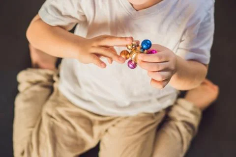 Young boy play with fidget spinner stress relieving toy Stock Photos