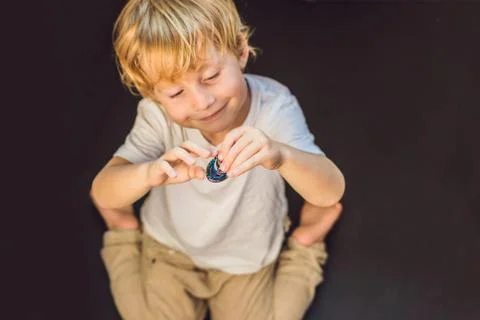 Young boy play with fidget spinner stress relieving toy Stock Photos