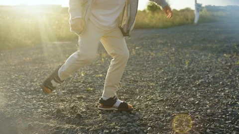 Young boy playfully kicks the pebbles on the land Stock Footage 119993044