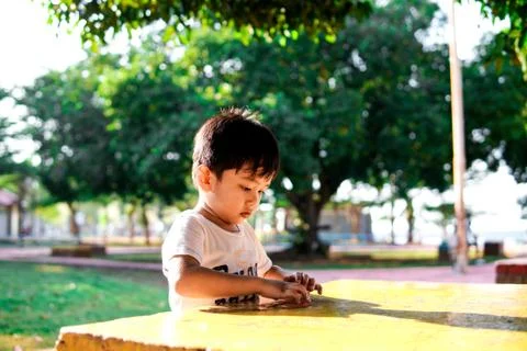 A young boy playing alone on a table at a park Stock Photos