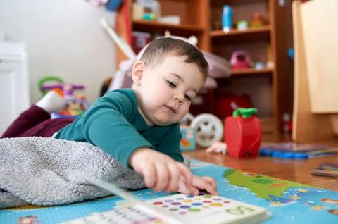 Young boy playing and looking at books in his room Fotos Stock