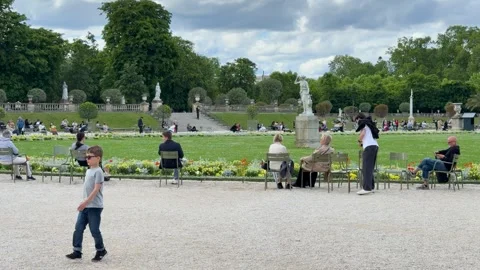 Young Boy Playing and Walking Across Gravel Pathway in Tuileries Garden Stock Footage 346664478