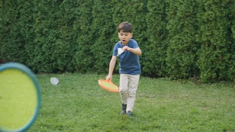 Young boy playing badminton on grass in backyard Stock Footage 119991407