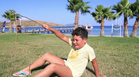 Young boy playing on beach and smiling to camera Stock Footage 64765460