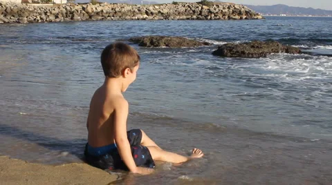 A young boy playing on the beach Stock Footage 1067491