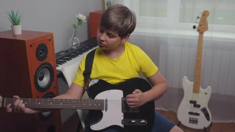 Young Boy Playing Black Electric Guitar At Home Room Music Lesson 库存影片 342034454
