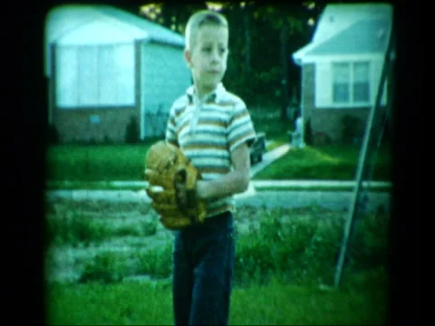 Young boy playing catch with baseball in suburban backyard Stock Footage