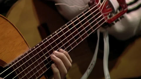 Young Boy Playing a Classical Guitar Decorated with an Argentine Ribbon. 스톡 동영상 243049409