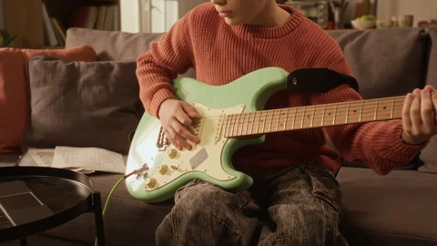 Young Boy Playing Electric Guitar at Home Following Online Lesson Stock Footage 333417702