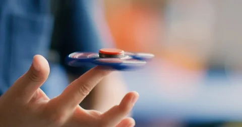 Young boy playing with a fidget spinner at school Stock Footage 108786189