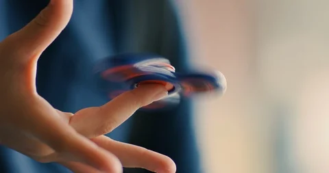 Young boy playing with a fidget spinner at school Stock Footage 108786371