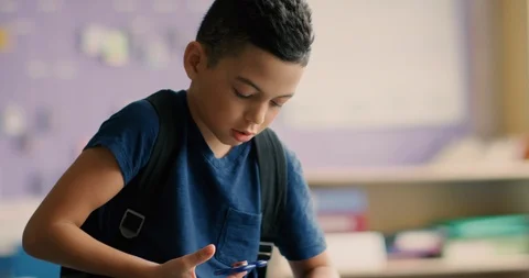 Young boy playing with a fidget spinner at school Stock Footage 108786597