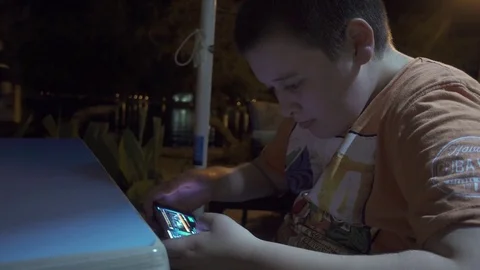 Young boy playing a game on smartphone Stock Footage 84087666