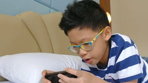 Young boy playing games on smart phone Stock Footage 79910407