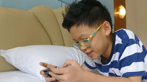 Young boy playing games on smart phone Stock Footage 79910999