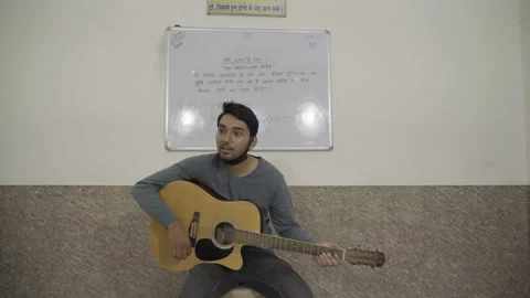 Young boy playing guitar &amp; singing music. Stock Footage 134681645