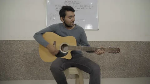 Young boy playing guitar &amp; singing music. Stock Footage 134682652