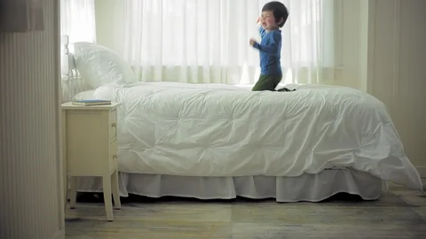 Young boy playing on his bed in his bedroom. 스톡 동영상 88341876