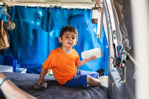 Young boy playing inside a camper van Stock Photos