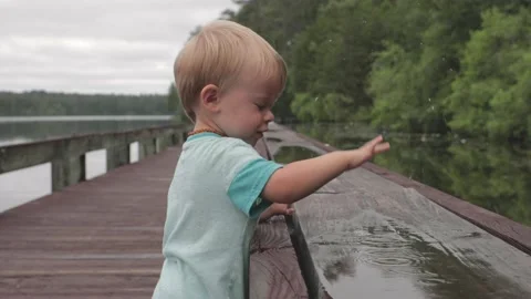 Young boy playing in puddle in nature Stock Footage 131751673