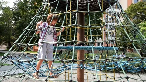 Young boy playing on ropes in a park Stock Footage 44430548