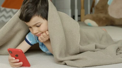 Young boy playing smartphone tablet at home 4K R3D Video stock 129050385