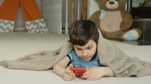 Young boy playing smartphone tablet at home 4K R3D Stock Footage 129050619
