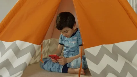 Young boy playing smartphone tablet at home 4K R3D Video stock 129051359