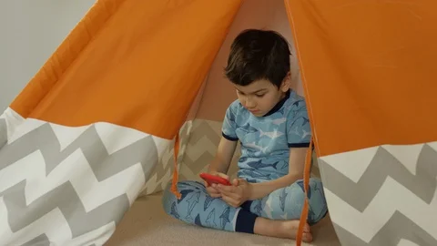 Young boy playing smartphone tablet at home 4K R3D Video stock 129051454