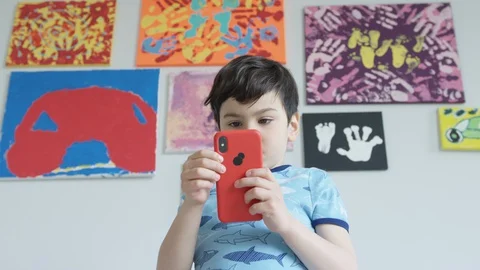 Young boy playing smartphone tablet at home 4K R3D Video stock 129051694