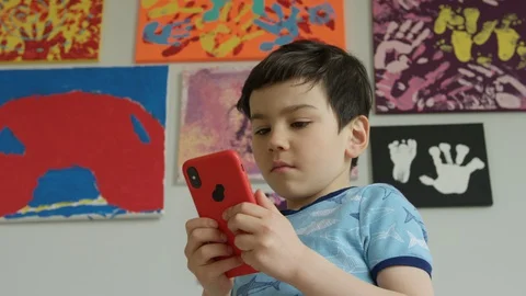 Young boy playing smartphone tablet at home 4K R3D Video stock 129051731