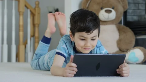 Young boy playing smartphone tablet at home 4K R3D Video stock 129052753