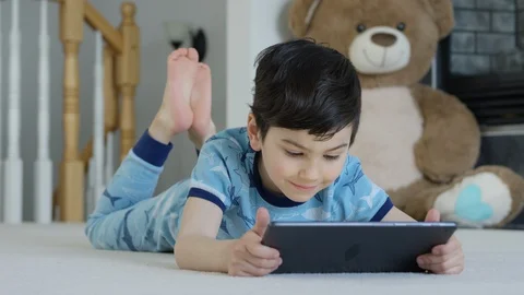 Young boy playing smartphone tablet at home 4K R3D Video stock 129053029