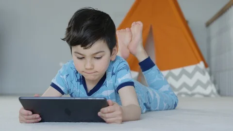 Young boy playing smartphone tablet at home 4K R3D Video stock 129053139