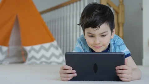 Young boy playing smartphone tablet at home 4K R3D Video stock 129053369