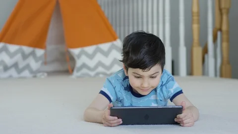 Young boy playing smartphone tablet at home 4K R3D Video stock 129053388
