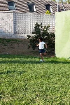 Young boy playing soccer in the backyard of his house Foto stock