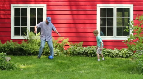 Young boy playing soccer with his grandfather Stock Footage 6117003