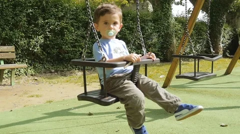 Young Boy Playing On A Swing Видео 50083336