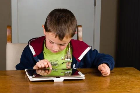 Young boy playing on tablet computer Stock Photos